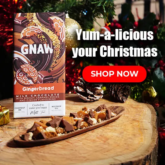 Gingerbread chocolate bar with a 'GNAW' label on a wooden surface, surrounded by Christmas decorations.